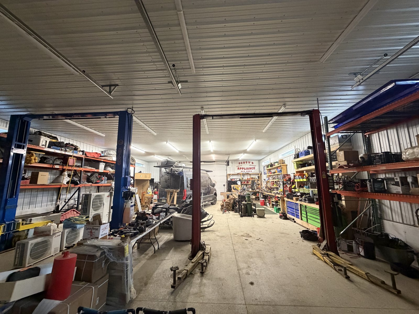 Inside the Homestead Heroes fabrication shop &mdash; two vehicle lifts and racking down both walls